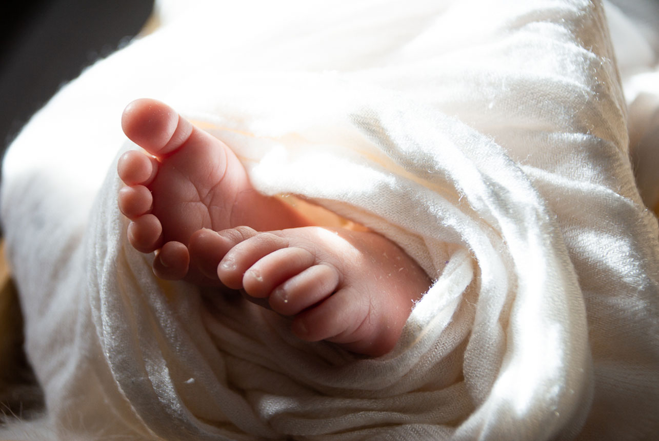 Tiny Toes Bathed in Sunlight - Swaddled Baby with Adorable Feet Exposed