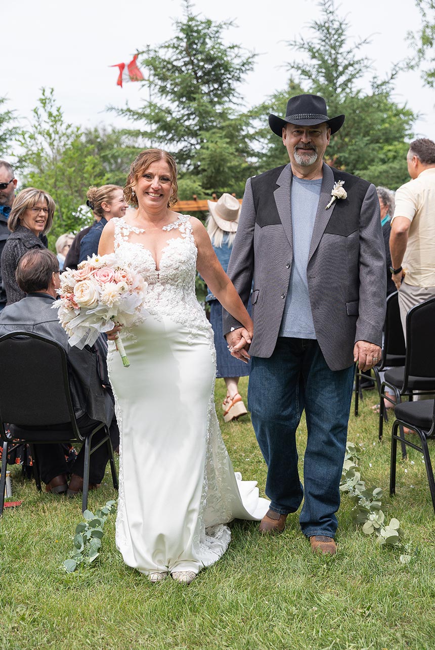 Bride and groom walk down the aisle smiling after ceremony
