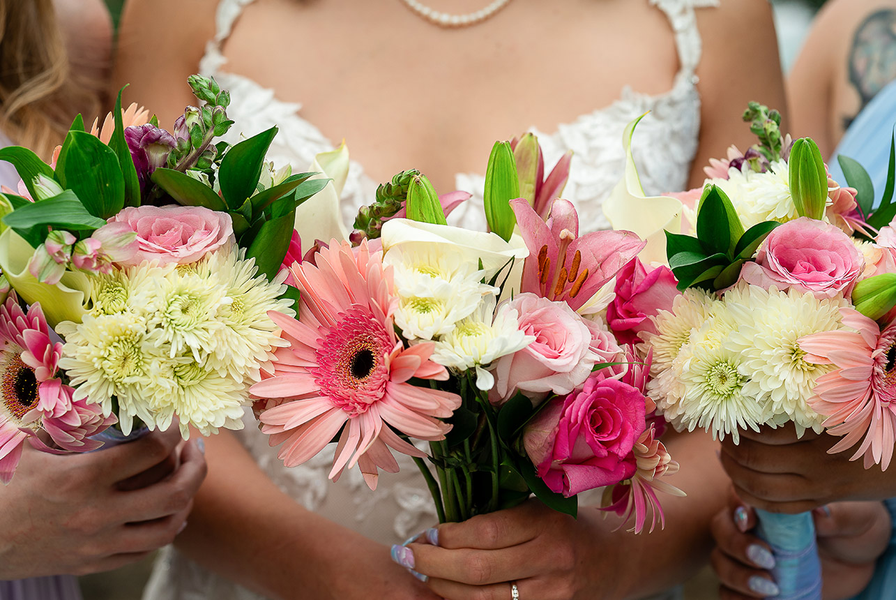 A bride standing with her bridesmaids, all holding flower bouquets during a wedding ceremony at Greenland Botanic Gardens in Sherwood Park, near Edmonton.