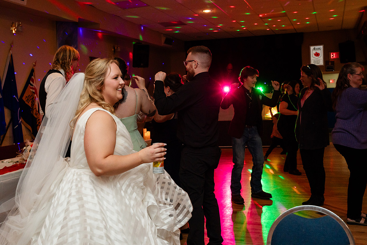 Bride and groom dance together on the floor with flashing lights creating a party atmosphere at their reception