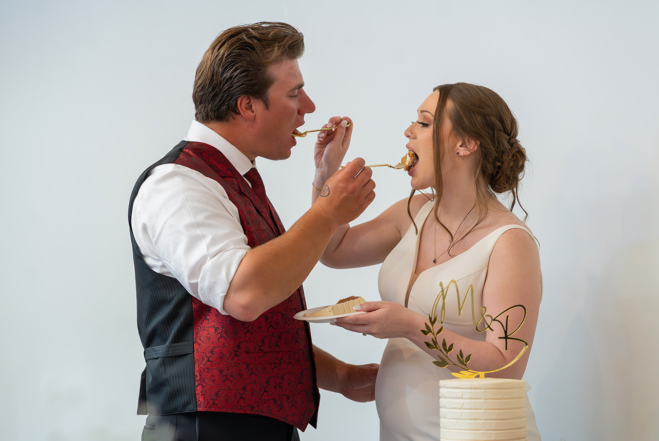 Bride and groom feed each other wedding cake
