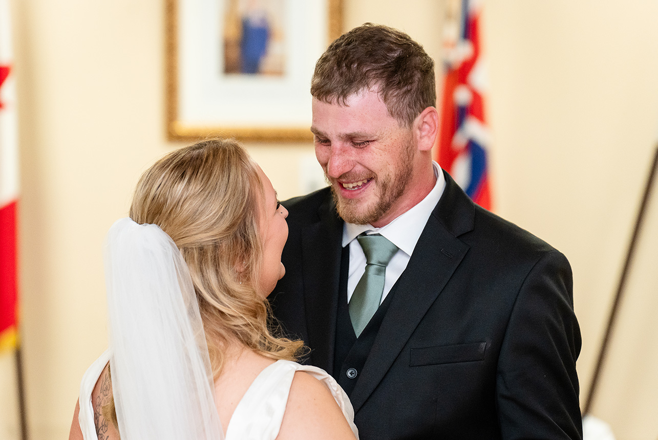 Bride and groom share their first dance, gazing into each other’s eyes under soft lighting