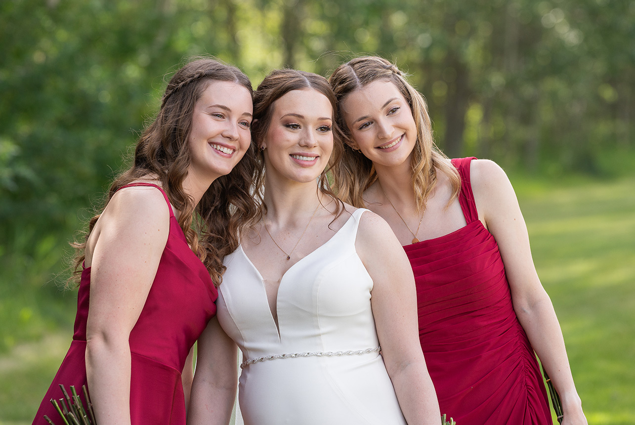 Bride posing with bridesmaids in red dresses
