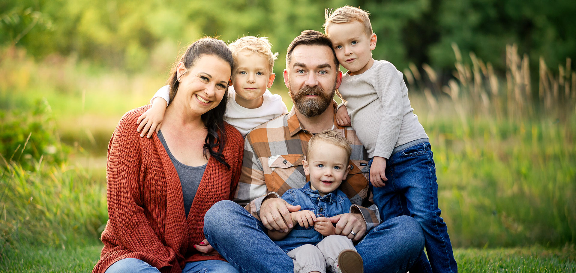 Smiling family of five with three young sons at a golden‑hour photo session in Sherwood Park, Edmonton