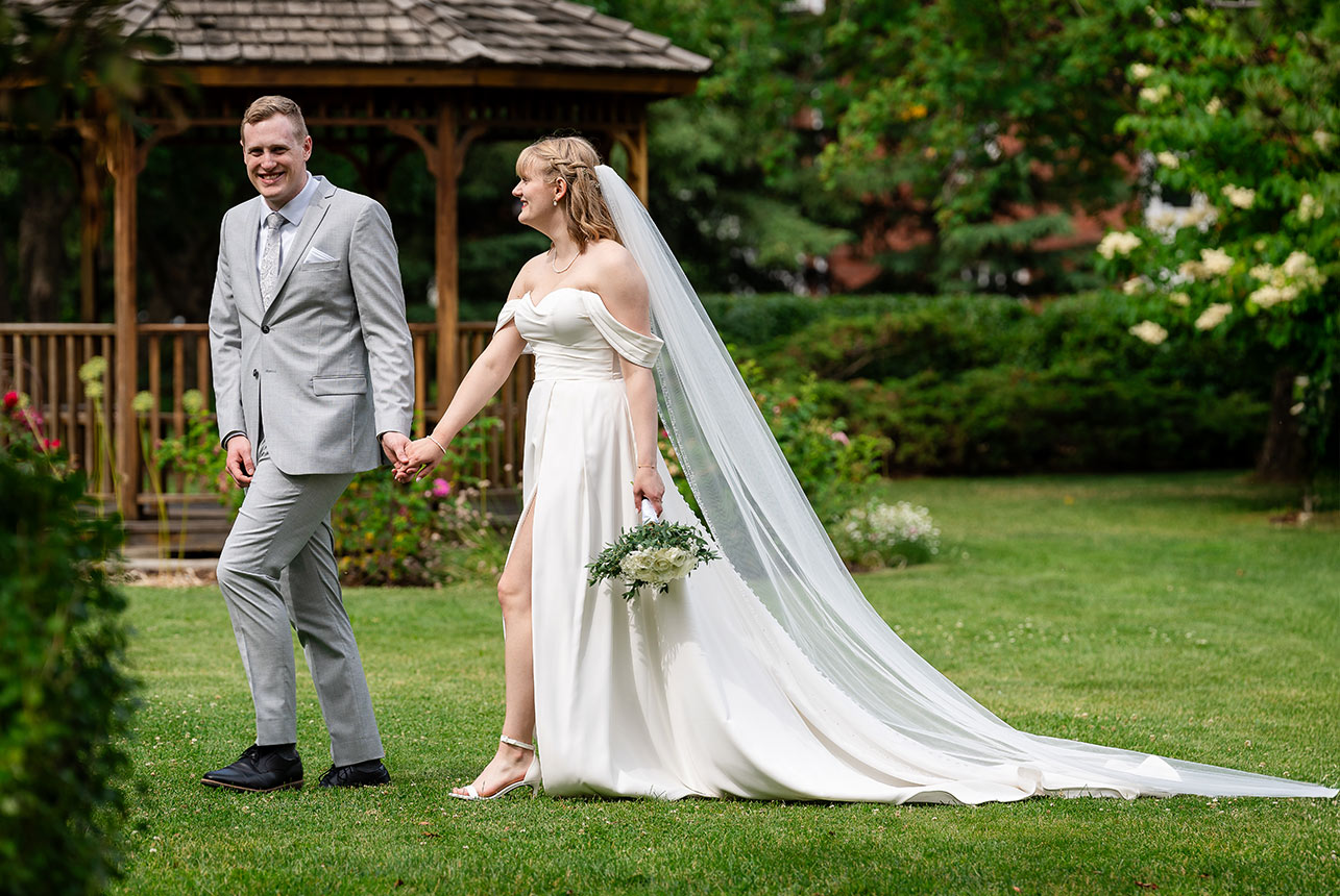 erin-eric-walking-garden-smeltzer Newlyweds walking hand-in-hand past the gazebo at Smeltzer House