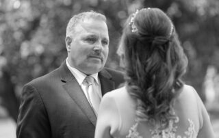 Groom looking emotionally at bride during vows in black and white