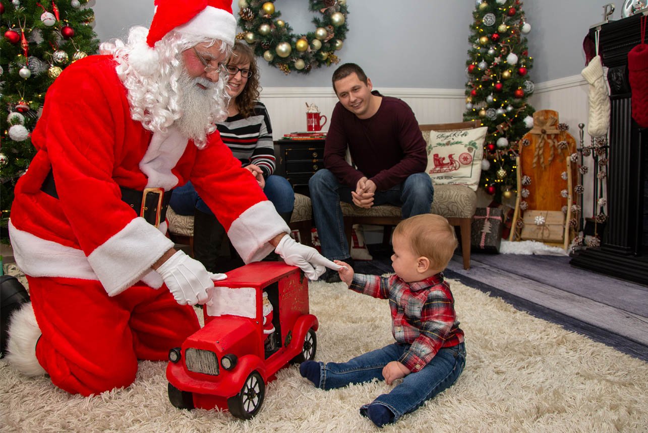 Little boy pulling Santa's finger